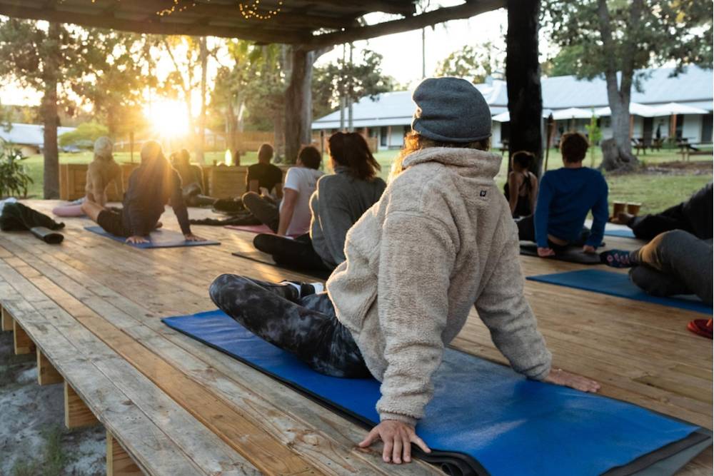 Group yoga session at sunrise as part of Psilocybin Retreats in Jamaica, promoting mindfulness and inner healing in a natural setting.