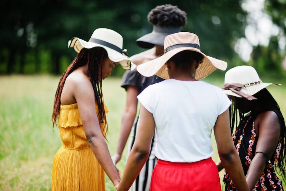 A large group practices outdoor movement exercises in a forested retreat space with tents, part of a community healing event during Iboga Retreats in Costa Rica.