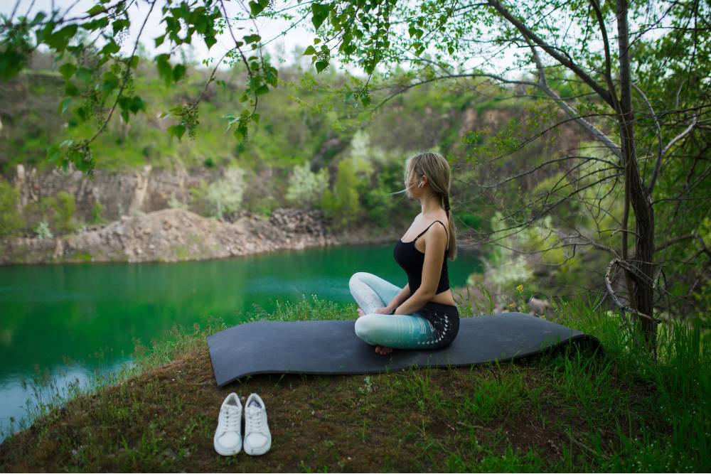 Peaceful moment of meditation beside a green riverbank at Bufo Retreats in Mexico.