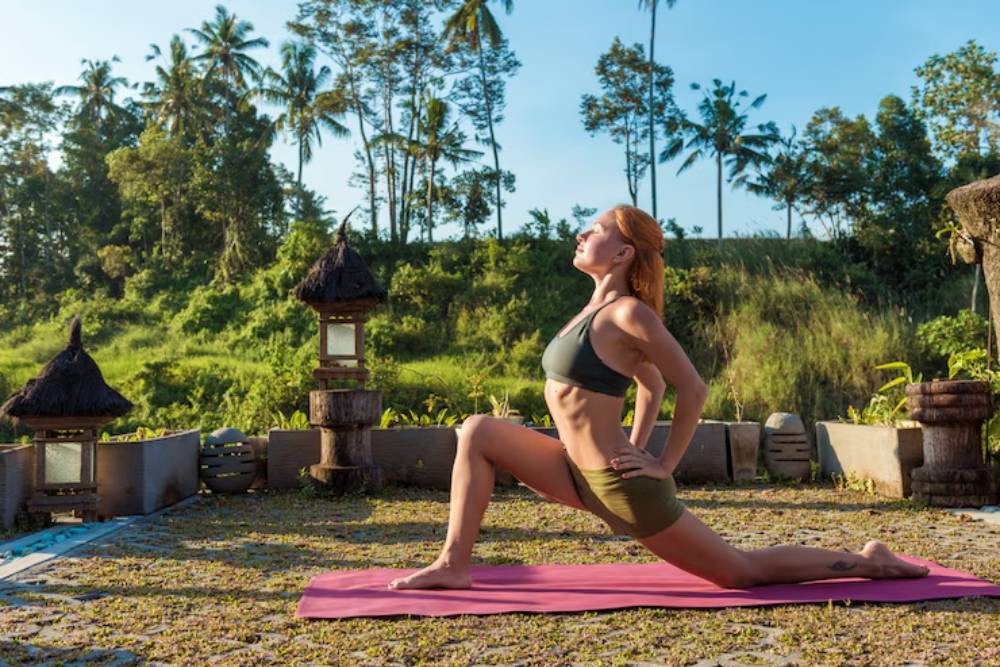 Woman doing yoga stretches at sunrise during Bufo Retreats in Mexico, set in a serene jungle retreat.