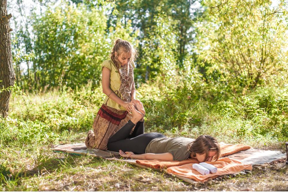 A therapist performs bodywork on a participant during a nature-based session, illustrating the therapeutic practices at Bufo Retreats in the United States.